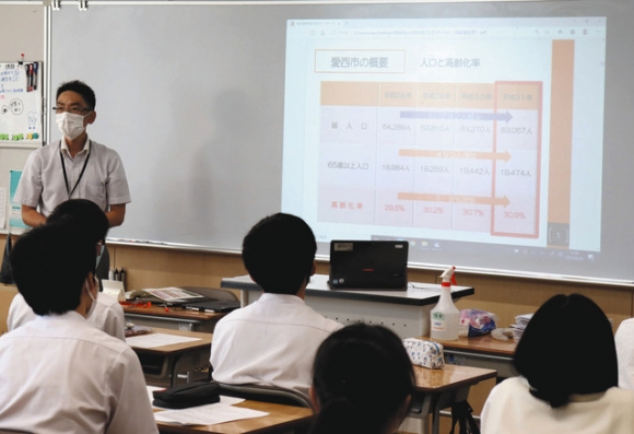市の課題について語る市職員の説明を聞く生徒たち=愛西市持中町で