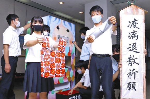 マスクとエコバッグの自動販売機を製作した東海学園高の生徒ら。奥にあるのが自販機=天白区中平の同高で