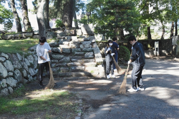 公園内の枯れ葉を集める生徒たち=津市丸之内のお城公園で