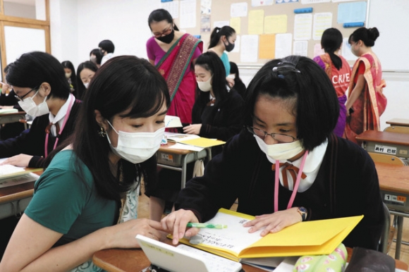 卒業生に手伝ってもらい翻訳する高校生=瀬戸市せいれい町の聖霊中・高で
