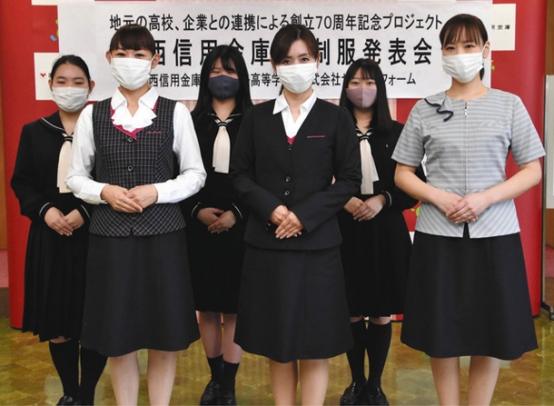 修文女子高生（後列）がデザインした尾西信用金庫の新制服＝一宮市篭屋１の尾西信用金庫で