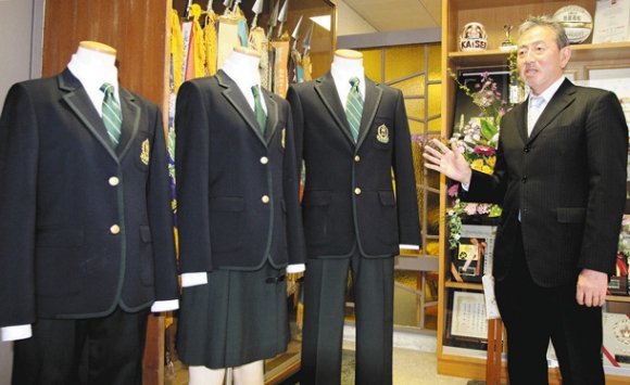 4月から導入される制服を紹介する下村校長。女子の制服はスカート(中)とスラックス(左)の2種類ある