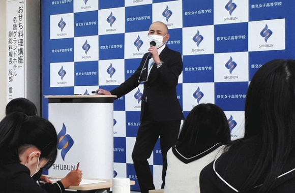おせち料理の歴史や特徴について話す名鉄グランドホテルの服部副総料理長=一宮市日光町の修文女子高で