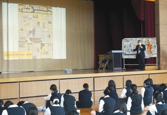 新聞切り抜き作品の作り方を生徒たちに伝える二宮さん(右端)=昭和区の南山高女子部で