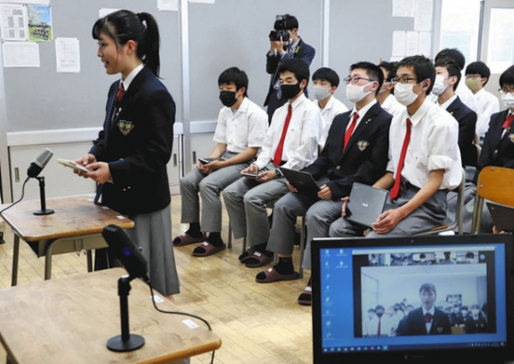 オンラインで参加している韓国の生徒に向けて、英語で話す高山西高の生徒=高山市の同校で