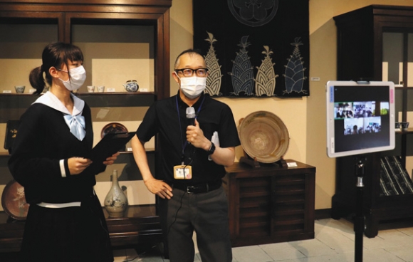 ビデオ会議アプリを使って展示を紹介する学芸員(右)と生徒=豊田市平戸橋町の市民芸館で
