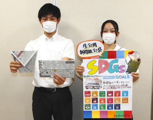 古新聞で作ったごみ袋と、ポスターを手にプラごみの削減を呼び掛ける生徒たち=稲沢市西町1の愛知啓成高で