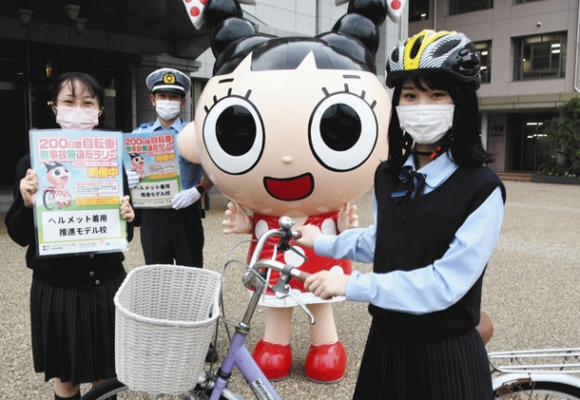 ヘルメットのイメージアップに協力する生徒ら=西区新道1の啓明学館高で