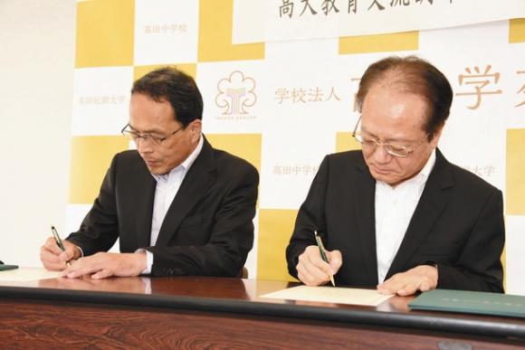 協定書に署名する高田短大の栗原学長(右)と三重高の中谷校長=津市の高田短大で