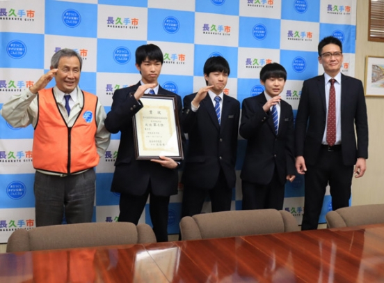 吉田市長とサーブのポーズをとる栄徳高卓球部の３人＝長久手市役所で