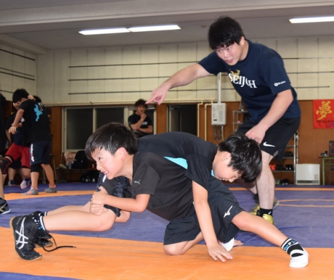 瀬野監督の指導を受けながらスパーリングをする子どもたち＝豊明市の星城高で