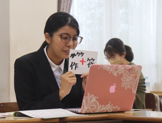 自作の紙のスライドを使い授業をする藤本さん=津市半田のセントヨゼフ女子学園で