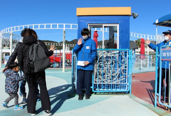 職場体験で、来園した親子に手を振る中学生（中央）＝蒲郡市のラグナシアで