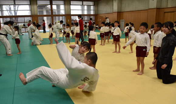 柔道部員を相手に投げの練習をする園児たち＝江南市東野町の滝中・高柔道場で