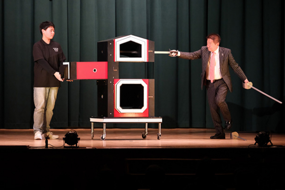 喜多さん（右）とともにマジックを披露する生徒＝昭和区の南山学園講堂で