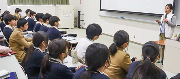 生徒に語りかける上西さん（右）＝津市一身田町の高田中で