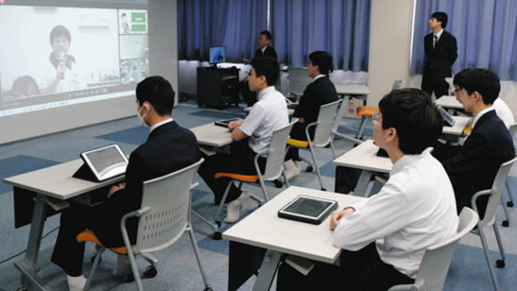 台湾の中学生（画面上）の話に耳を傾ける皇学館中の生徒たち＝伊勢市の同中で