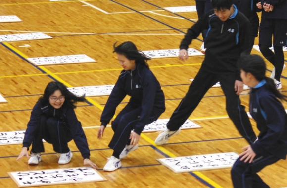 読まれた百人一首の下の句が書かれた札を探す生徒=岐阜市の鶯谷中学・高校で