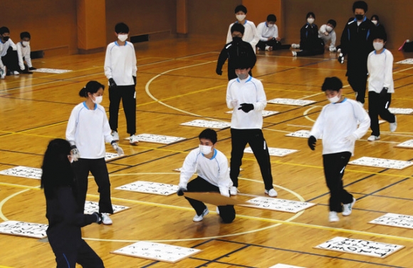 ジャンボサイズの札を拾う生徒=岐阜市鶯谷町の鶯谷中学・高校で