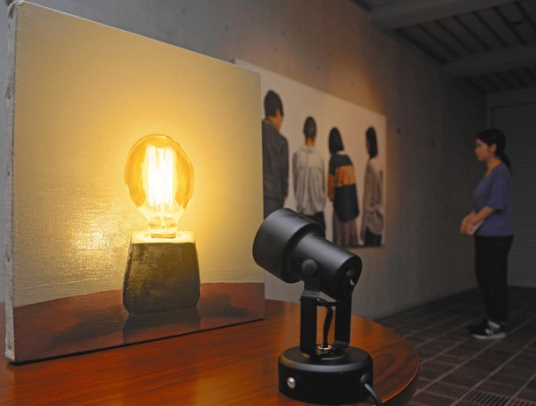 ライトを描いた油絵を本物の電灯が照らす作品などが並ぶ会場＝長久手市の県立芸術大で