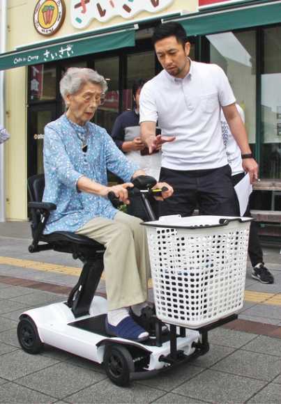 電動車「SCOO」に体験乗車する実験の参加予定者。右は大同大の樋口恵一講師=名古屋市緑区で(白名正和撮影)