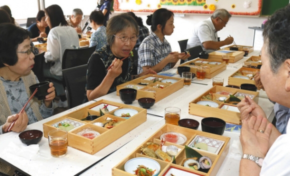 学生の手作り弁当を食べるお年寄りたち=瑞浪市土岐町の中京学院大短期大学部で