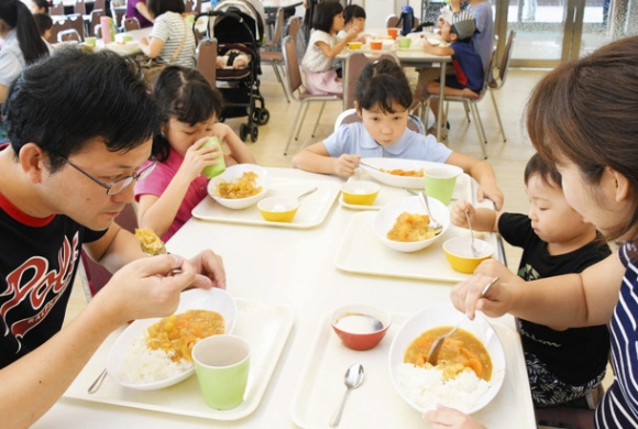 各務原にんじんたっぷりカレーを味わう家族ら＝１５日、各務原市の東海学院大で