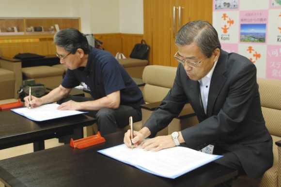 覚書に署名する山岡学長（右）と冨田市長＝７月３０日、可児市役所で