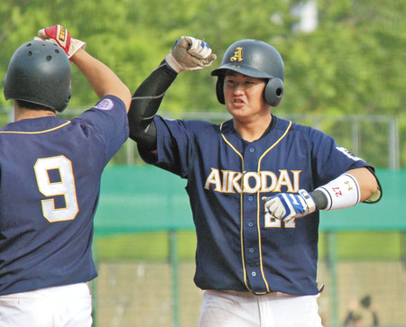 9回に決勝2ランを放ってハイタッチで生還する愛工大・山本航樹内野手=パロマ瑞穂球場で(川越亮太撮影)