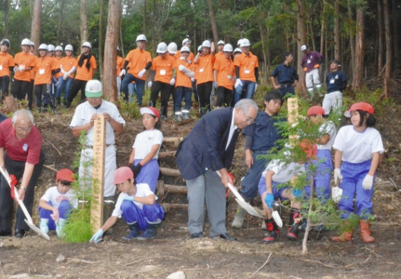 加子母小の児童と記念植樹する松原学長（中）と青山市長（左端）ら＝岐阜県中津川市加子母の「令和ともいきの森」で