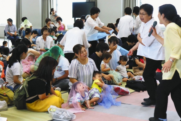 童歌で手遊びする来場者ら＝５日、関市の中部学院大関キャンパスで