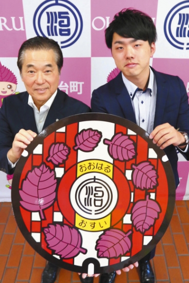 マンホールの新デザイン完成を喜ぶ最上さん（右）と村上町長＝大治町役場で