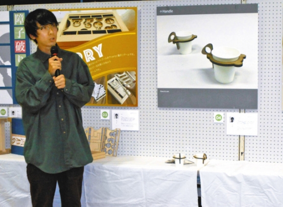 熊野産の木材で作ったおもちゃを紹介する学生＝熊野市文化交流センターで