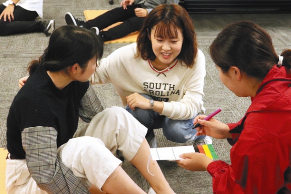 学生たちにトリアージ・タッグの記入方法を指導する愛知医科大看護学部の池原さん（中）＝長久手市の愛知医科大で