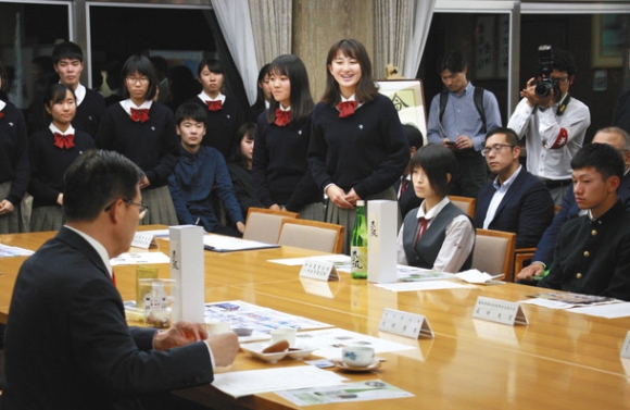 商店街と協力して開発した商品を大村知事（手前左）にＰＲする生徒ら＝県公館で