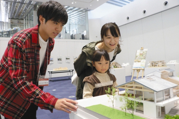 来場者に模型の解説をする学生（左）＝野々市市の「学びの杜ののいち　カレード」で