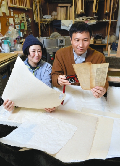 「サマルカンド紙」の復元を目指す柴崎幸次教授(右)と非常勤講師の浦野友理さん。浦野さんが持つのが、ウズベキスタンの麻布を使ってすいた紙=愛知県長久手市の県立芸術大で(太田朗子撮影)