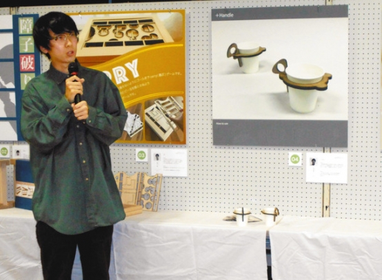 熊野産の木材で作ったおもちゃを紹介する学生＝三重県熊野市文化交流センターで