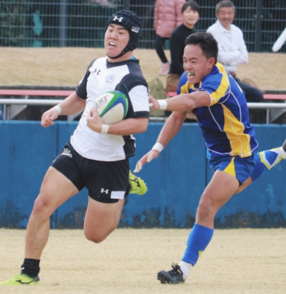 相手守備をかわし、トライを決める朝日大の選手(左)=岐阜市の長良川球技メドウで