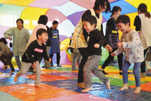 カラフルなバルーンの中に入って遊ぶ子どもたち=美浜町の上野間保育所で
