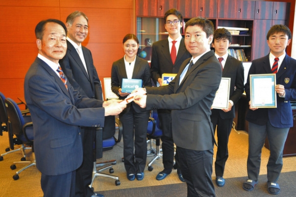 春田専務（左端）と垣尾常務理事（左から２人目）に目録を手渡す栗本法人本部長と学生ら＝名古屋市昭和区で