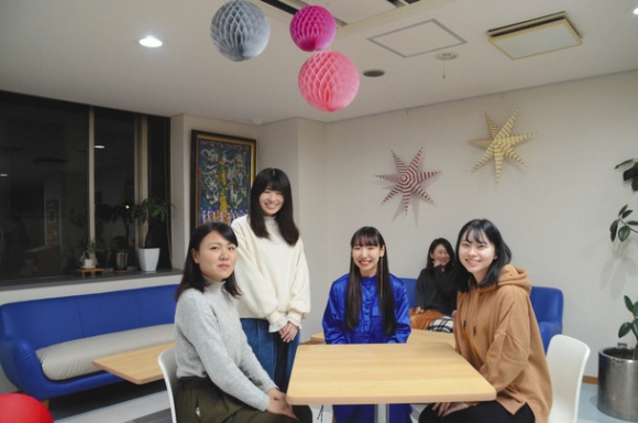 デザインしたロビーで談笑する石川さん(右)ら=中区の名古屋YWCAビルで