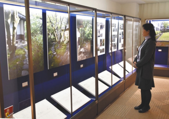 庭園の写真と設計図面のパネルが並ぶ会場＝春日井市松本町の中部大民族資料博物館で