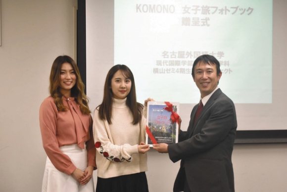 柴田町長（右）にフォトブックを渡す志村さん（中）と林さん＝菰野町役場で