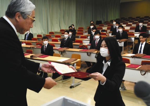 古田学長（左）から学位記を受け取る経営学科の卒業生代表＝各務原市の中部学院大各務原キャンパスで