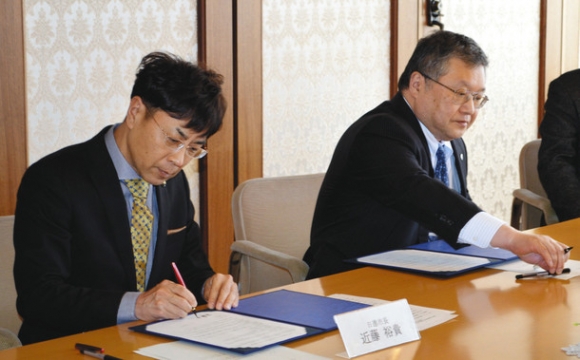 協定書に署名をする近藤市長（左）と才藤学長＝日進市役所で