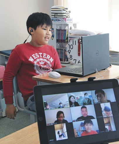 ズームを使ったオンライン学習支援で、指導役の大学生や他の生徒らと話すミン君=愛知県西尾市の鶴城小で