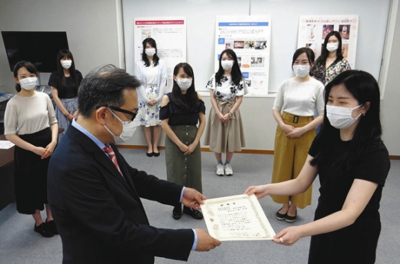 北嶋中日新聞社電子メディア局長（左）から感謝状を贈られる岩井さんら＝守山区大森の金城学院大で