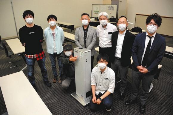 空気清浄機（中央）の自動走行型への改良に取り組むメンバーら＝瀬戸市蔵所町で