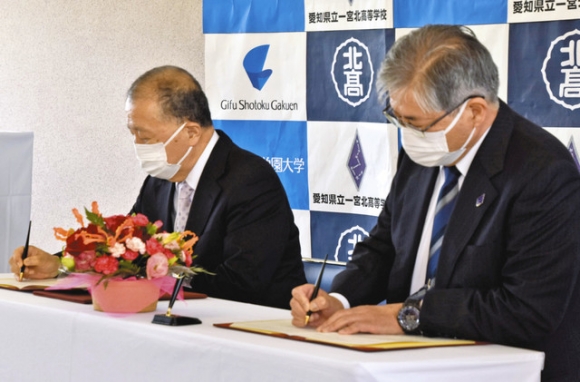 協定書に調印する一宮北高の牧野文輔校長(右)と岐阜聖徳学園大の藤井学長=一宮市笹野の一宮北高で